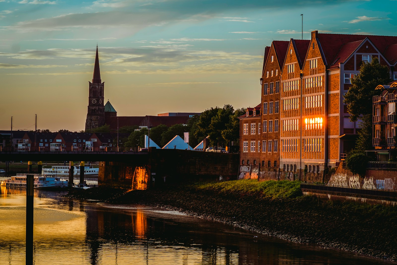 A view of a river with a bridge and buildings in the background